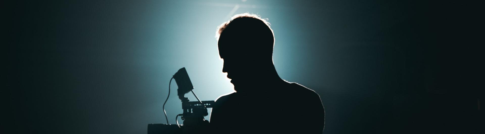 Silueta de home con cámara a contraluz
